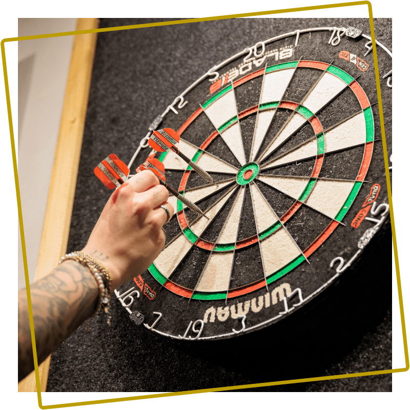 Dartpijlen op een dartbord in de sportsbar bij Kings & Queens in Assen
