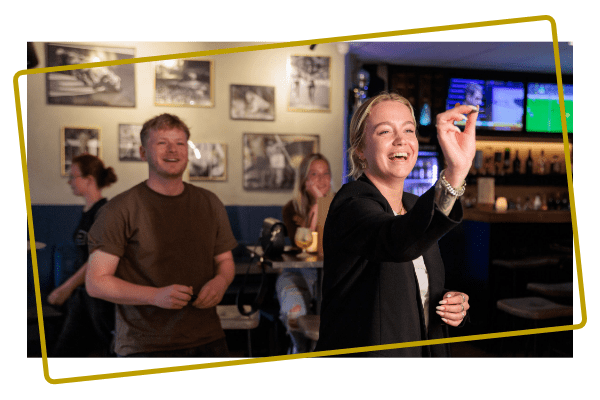 Vrienden spelen een potje darts in de sportsbar bij Kings & Queens in Assen