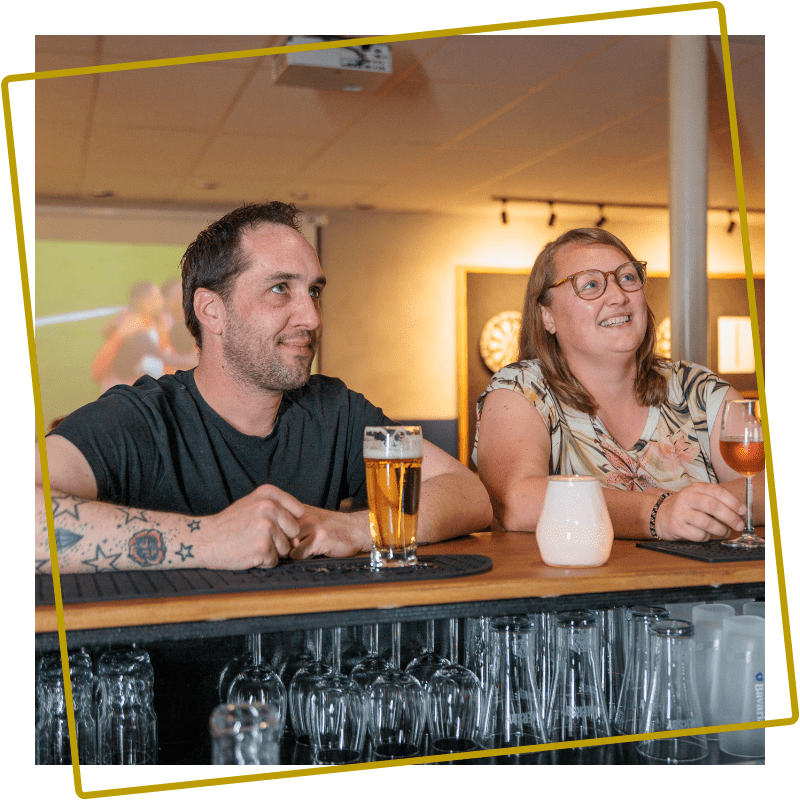 Man en vrouw genieten van een drankje in de Sportsbar van Kings en Queens Assen