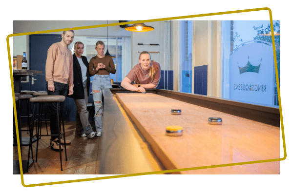 Groep vrienden speelt samen shuffleboard in Assen